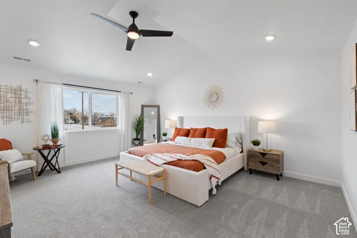 Vaulted ceilings featuring recessed lighting and a central ceiling fan with an integrated light fixture, paired with neutral carpeting and a large window
