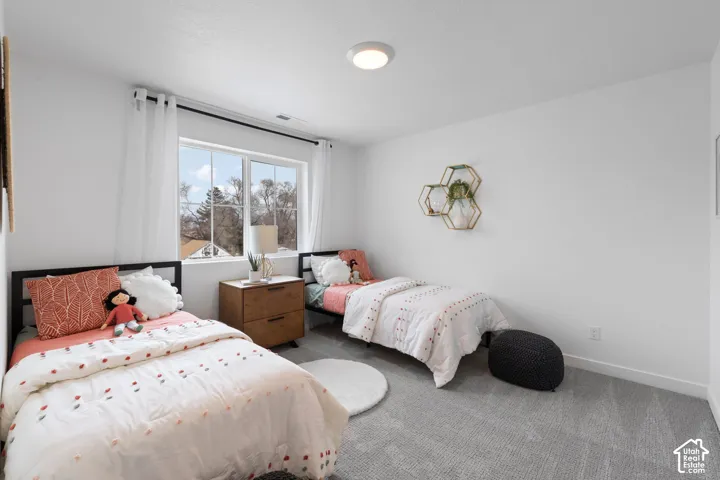 Bedroom featuring neutral wall paint, wall-to-wall carpeting, a large window, and a flush-mount ceiling light fixture