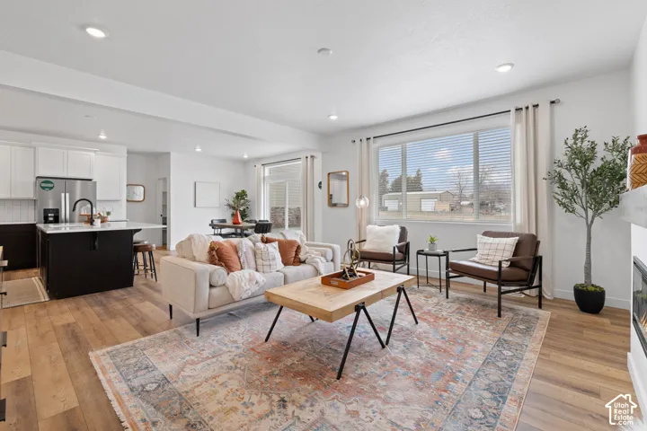 Open-concept interior featuring wood-finish flooring, recessed lighting, and a kitchen island with a stone-surface countertop