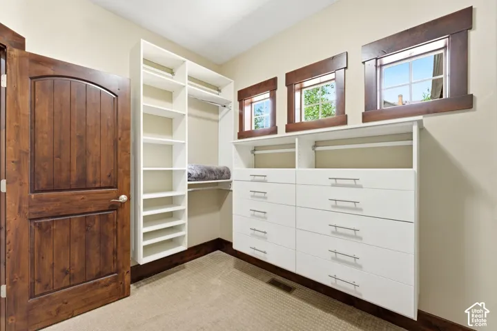 Custom built-in storage system with white shelving, stacked drawers, and metallic pulls, complemented by solid wood-finish door and window trim