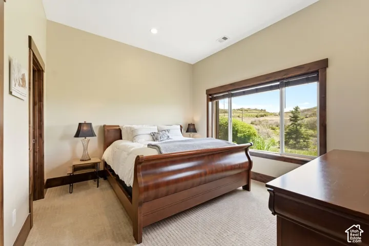 Vaulted ceiling featuring recessed lighting, extensive wood trim, and a large horizontal window showcasing mountain terrain
