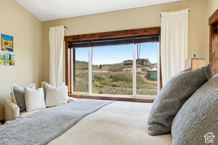 Large picture window with custom stained-wood casing, showcasing expansive natural surroundings