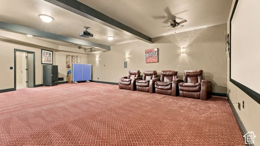 Spacious room featuring a projector system, large wall-mounted screen, recessed ceiling lighting, textured wall finish, and overhead ceiling fan