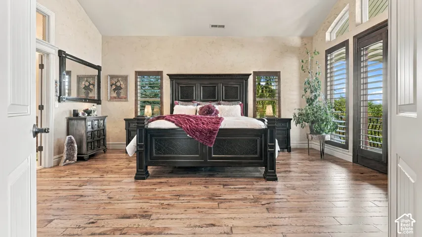 Vaulted ceilings, wood-finish flooring, plantation shutters, and glass-paneled exterior door