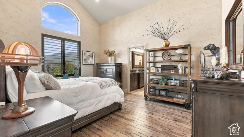 Vaulted ceilings, arched window with mountain scenery, wood-finish flooring, and wall-to-wall textured finishes