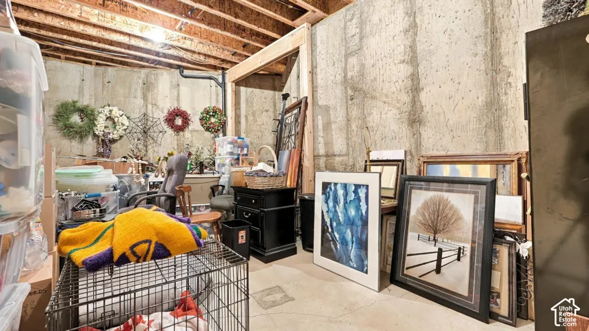 Unfinished basement featuring concrete walls and exposed ceiling joists