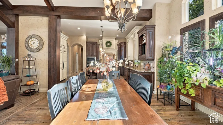 Open-concept interior featuring exposed dark wood ceiling beams, textured wall finish, and wood-finish flooring