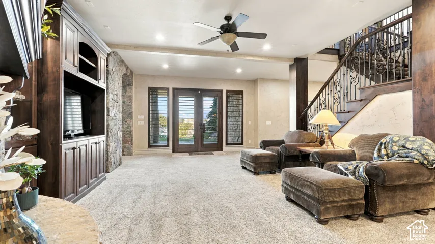 Custom built-in cabinetry, stone pillar accents, double front doors with glass panels, and an iron-railed staircase
