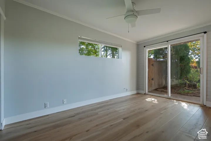 Wood-finish flooring, sliding glass door, horizontal accent window, and ceiling fan