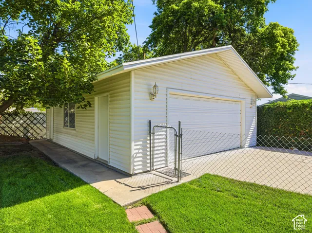Detached garage with horizontal vinyl siding and a roll-up door
