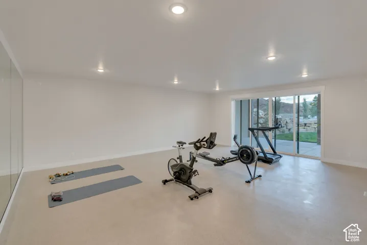 Spacious interior featuring recessed lighting, full-length wall mirrors, and large sliding glass doors providing outdoor access