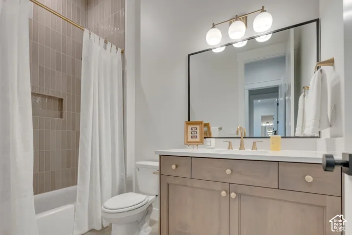 Bathroom featuring a vanity with light wood-finish cabinetry, a solid-surface countertop, and a black-framed mirror