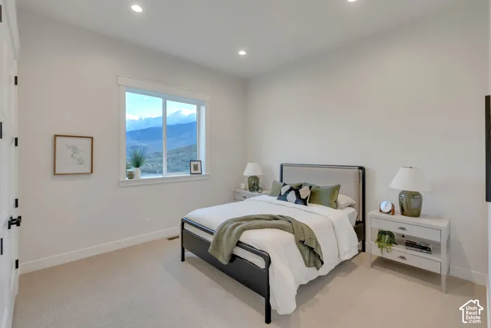 Neutral-toned interior featuring recessed lighting, plush wall-to-wall carpeting, and a wide window showcasing mountain scenery