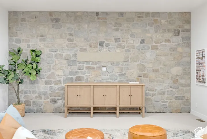 Floor-to-ceiling natural stone accent wall featuring multi-tonal irregular masonry and a centered recessed mount