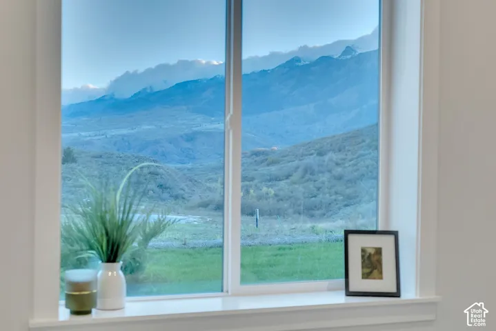 Single-hung window with white framing and sill, highlighting a panoramic mountainous backdrop