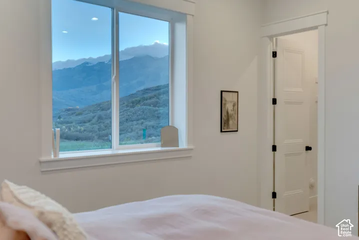 Large picture window featuring mountain scenery, minimalist white casing, and a multi-panel door with matte black hardware