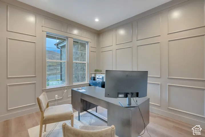 Room featuring floor-to-ceiling wainscoting, wood-finish flooring, and recessed lighting
