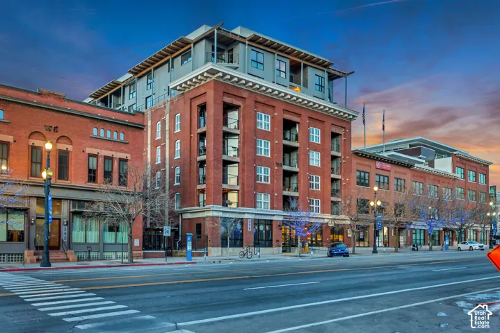 Multi-story brick exterior building featuring inset balconies, large-pane windows, and a tiered architectural design