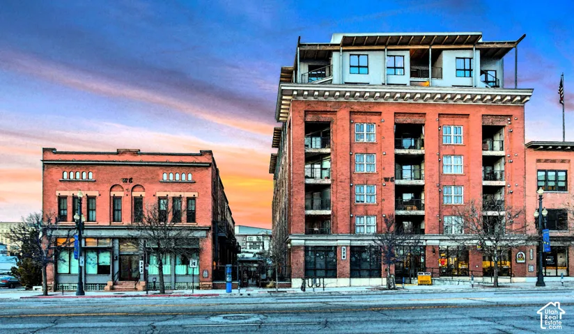 Multi-story brick exterior featuring classic architectural masonry, recessed private balconies, expansive multi-pane windows, and a prominent cornice detail
