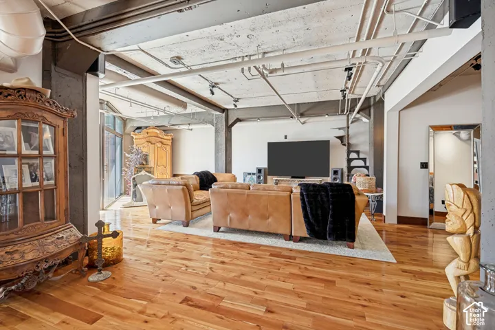Industrial-style interior featuring exposed concrete ceilings, steel structural columns, track lighting, and wood-finish flooring