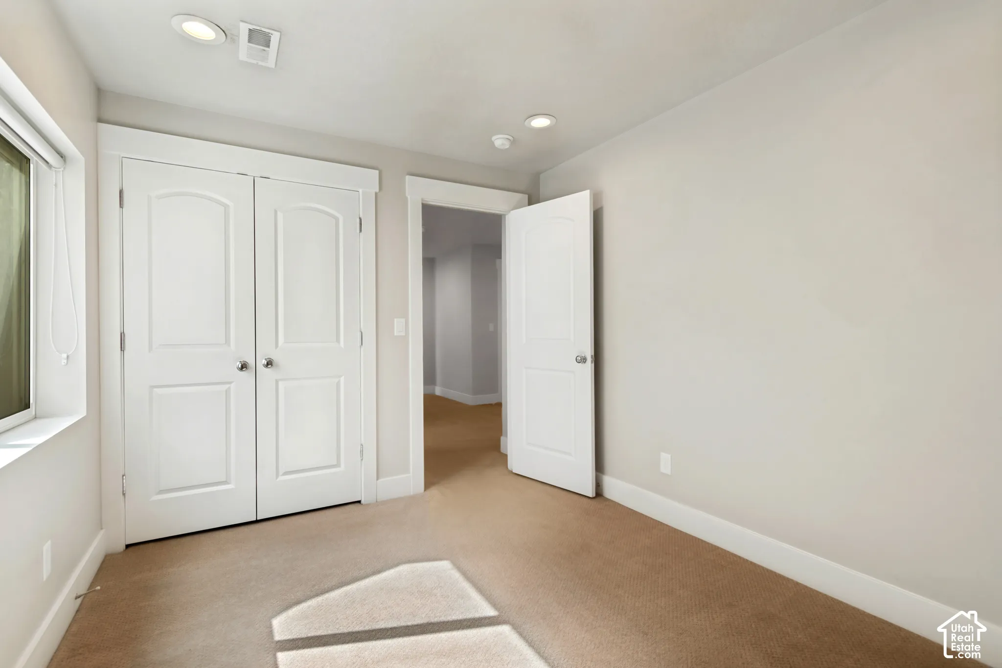 Neutral wall paint, plush carpeting, recessed lighting, white interior doors with satin nickel hardware, and multi-panel closet doors