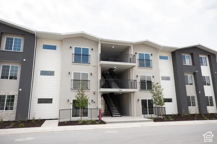 Front of building with balconies and landscaping.