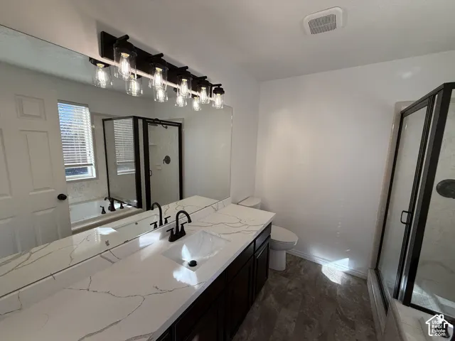 Vanity with a veined stone-finish countertop, dual under-mount sinks, matte black fixtures, dark cabinetry, and a multi-bulb vanity light