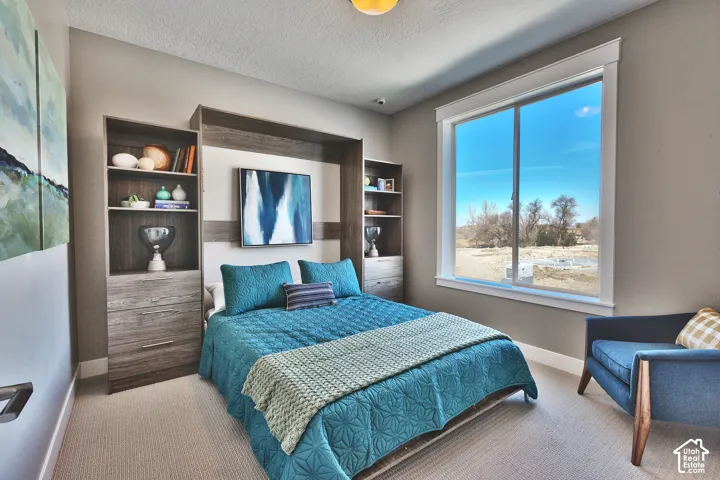 Built-in wood-finish cabinetry featuring open shelving and integrated drawers, large sliding window, and neutral carpeting