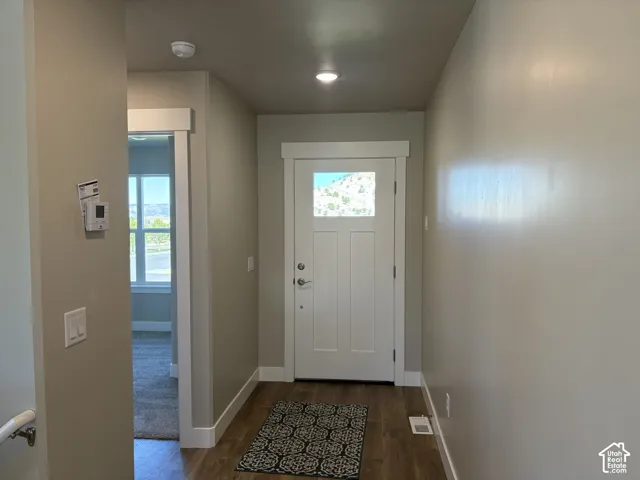 Entryway featuring wood-finish flooring, white door with an upper glass panel, and neutral wall tones