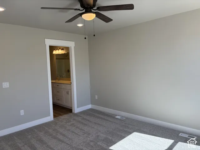 Neutral wall tones paired with textured carpeting and a ceiling fan with integrated lighting