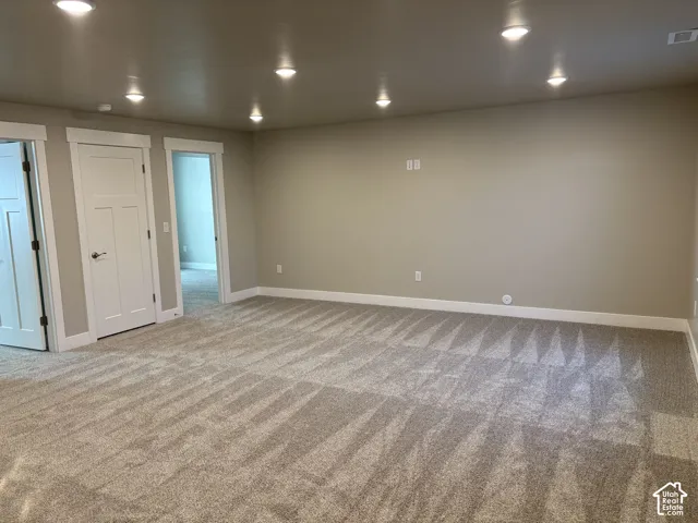 Interior room featuring wall-to-wall carpeting, recessed ceiling lighting, and solid-core interior doors with Craftsman-style trim