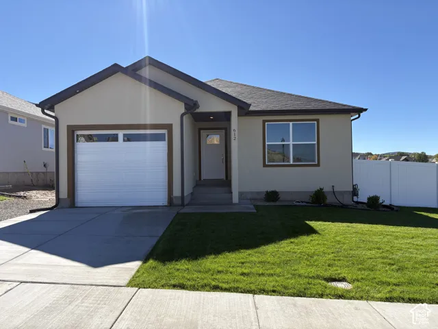 Single-story exterior featuring a stucco facade, attached one-car garage, concrete driveway, and front-facing window with grid detailing