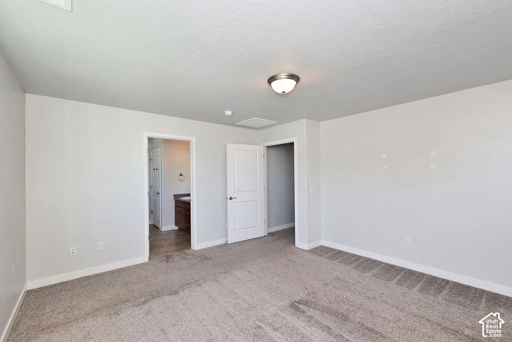 Interior room featuring wall-to-wall carpeting, neutral paint palette, flush-mount ceiling lighting, and solid-core paneled doors