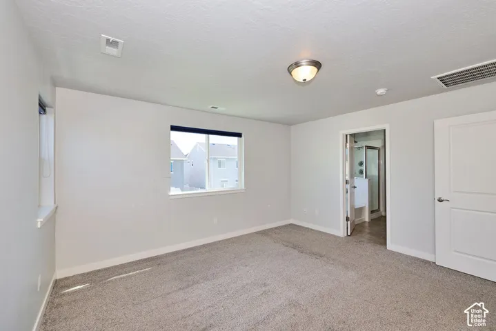 Neutral wall tones, wall-to-wall carpeting, dual-pane windows, and a solid-core interior door