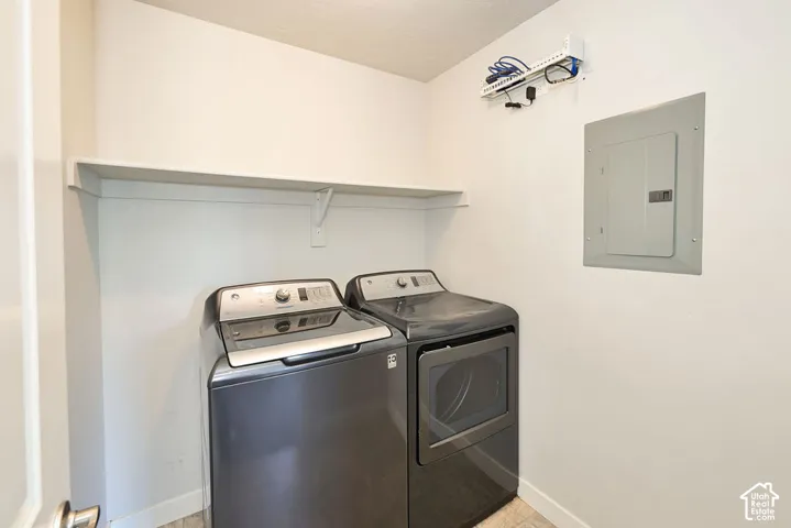 Utility area featuring a wall-mounted shelf, electrical panel, and organized network cabling hub