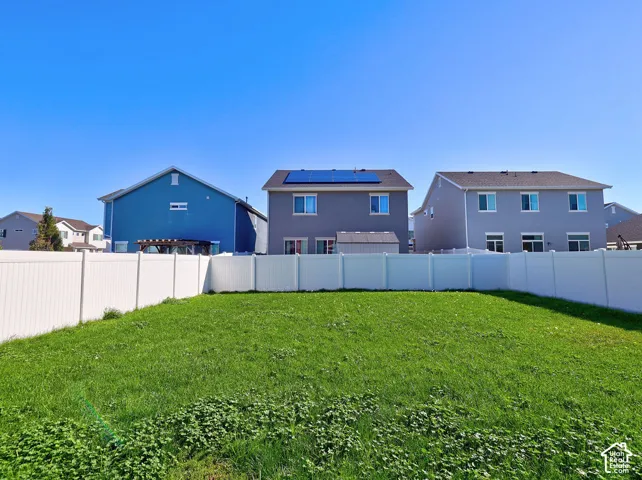 Expansive backyard featuring a level lawn and a full-perimeter white vinyl privacy fence