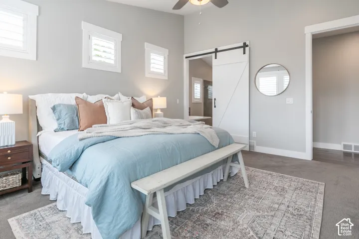 Vaulted ceiling with a central fan, white barn-style sliding door, and interior plantation-style window shutters