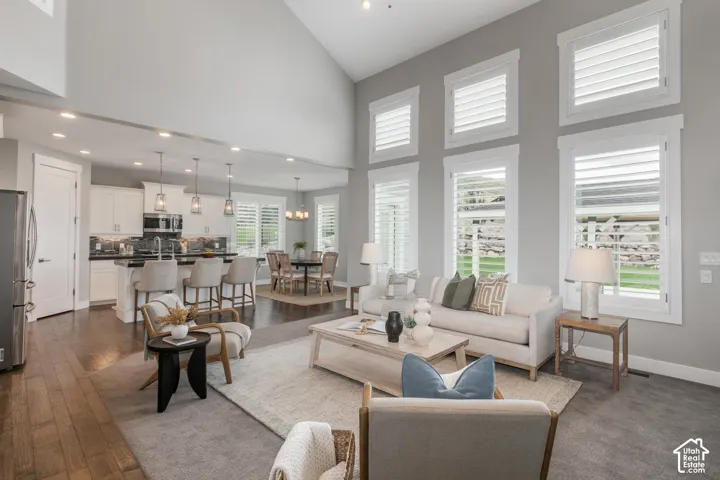 Vaulted ceilings, expansive windows with plantation shutters, recessed lighting, and wood-finish flooring