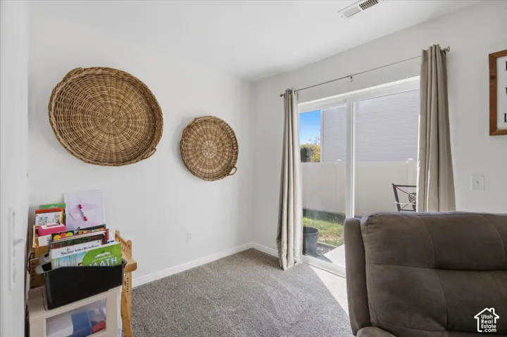 Sliding glass door with access to exterior patio, neutral wall-to-wall carpeting, and bright interior finish