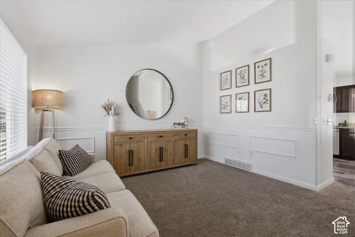 Neutral-toned interior space featuring white wall wainscoting and high-pile wall-to-wall carpeting