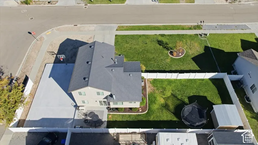 Corner lot property featuring an expansive concrete side parking area, fenced rear yard, and a concrete patio