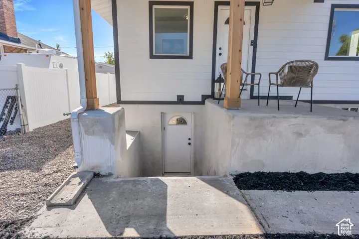 Exterior featuring horizontal siding, a concrete porch, natural wood support posts, and a separate ground-level entry