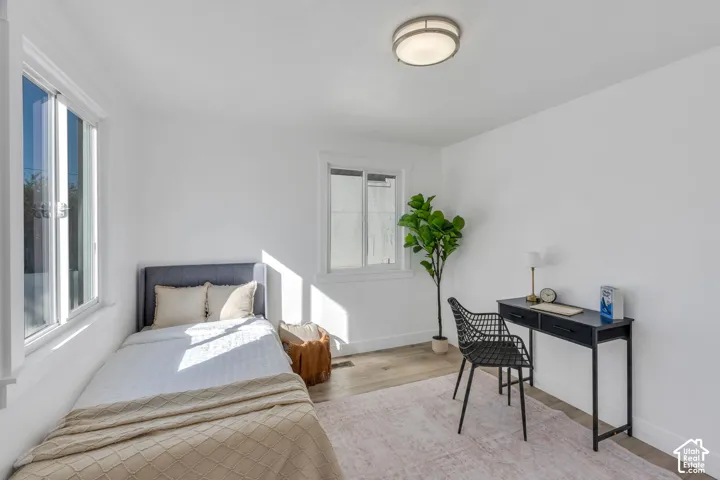Neutral interior room featuring wood-finish flooring, dual windows, and a flush-mount circular ceiling light fixture