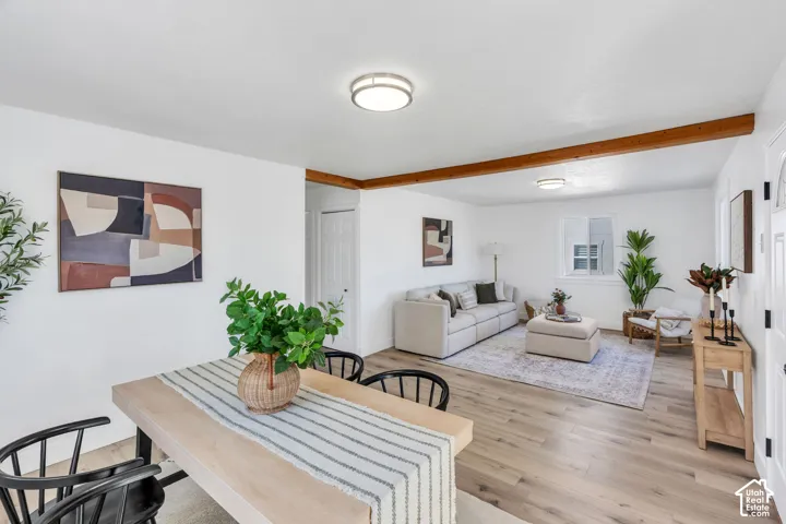 Wood-finish flooring, exposed natural wood ceiling beams, and dual flush-mount ceiling lights
