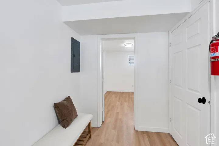 Interior area featuring wood-finish flooring, white walls, and a recessed doorway