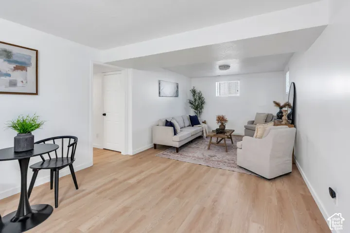 Neutral-toned interior space featuring wood-finish flooring, white walls, and a recessed ceiling light