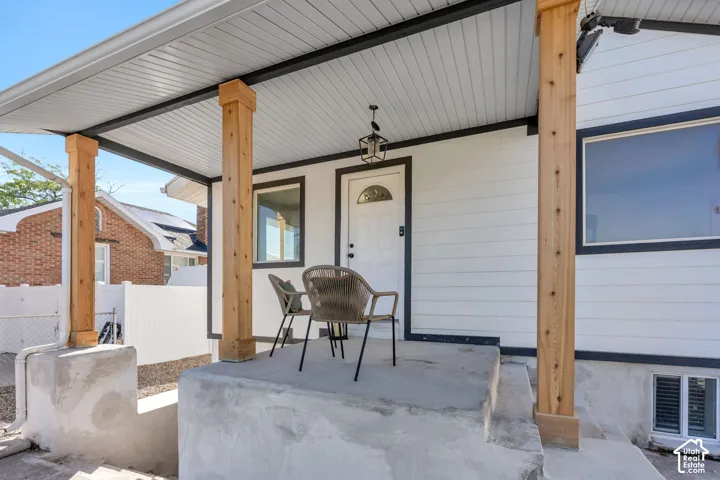 Covered front porch featuring exposed wood support columns, concrete foundation, and horizontal lap siding