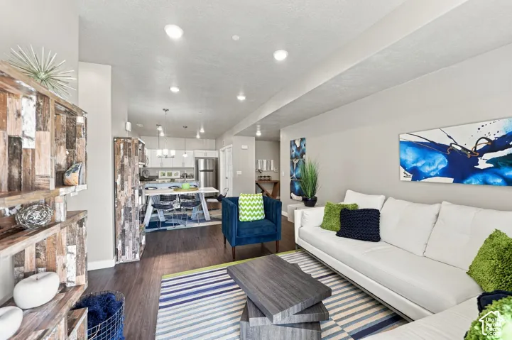 Open-concept interior featuring wood-finish flooring, recessed lighting, and stainless steel kitchen appliances