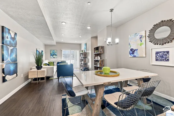 Open-concept living and dining area featuring wood-finish flooring, recessed lighting, and a multi-light brushed metal chandelier