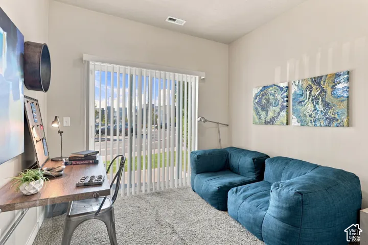 Room featuring high ceilings, wall-to-wall carpeting, and sliding glass doors with vertical blinds